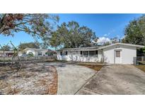Charming single-story home with a spacious driveway and classic white exterior nestled under mature trees at 3365 7Th St, Sarasota, FL 34237
