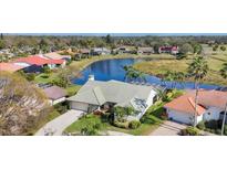 Stunning aerial view of a home with lush landscaping and a serene lake backdrop offering a peaceful neighborhood setting at 3445 Highlands Bridge Rd, Sarasota, FL 34235