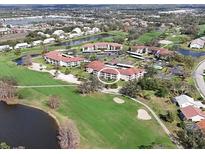 Scenic aerial view of a condo community, featuring a golf course and pond at 6501 Stone River Rd # 205, Bradenton, FL 34203