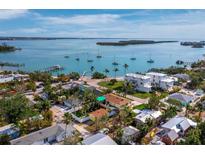 Beautiful aerial view of a waterfront home with boats on the water and nearby tropical landscaping at 691 Linley St, Longboat Key, FL 34228