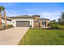 Stunning home with a paver driveway, two-car garage, stone accents, and meticulously landscaped yard at 16435 Umbria Pl, Bradenton, FL 34211