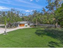 Beautiful single-story home with a well-manicured lawn and mature trees at 2855 Mira Loda Dr, Sarasota, FL 34240