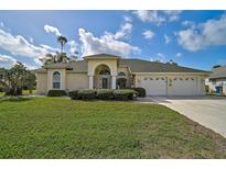 Inviting single-story home with a well-manicured lawn, a three-car garage, and an elegant arched entryway at 4306 Presidential Avenue E Cir, Bradenton, FL 34203