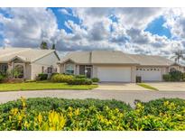 Well-maintained single-story home with attached garage, lovely landscaping, and a white tile roof at 5320 Crestlake Blvd # 26, Sarasota, FL 34233