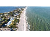 A stunning aerial view showcases beachfront property with a sandy beach and ocean views at 5611 Gulf Of Mexico Dr # 5, Longboat Key, FL 34228