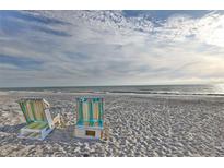 A calming beach scene with lounge chairs on the sand near the water at 5611 Gulf Of Mexico Dr # 5, Longboat Key, FL 34228