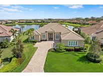 Inviting single-story home boasts lush landscaping, paver driveway and serene lake views for the ultimate curb appeal at 9641 Carnoustie Pl, Bradenton, FL 34211