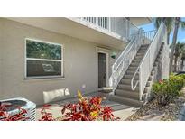 Inviting condo exterior with staircase leading to the upper level and lush landscaping at 966 La Costa Cir # 1, Sarasota, FL 34237