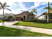 Charming single-story home featuring a well-manicured lawn, beautiful landscaping, and a stone facade at 11679 Renaissance Blvd, Venice, FL 34293