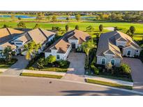 Stunning aerial view of a well-manicured home overlooking lush green golf course and serene blue lakes at 15520 Castle Park Ter, Lakewood Ranch, FL 34202