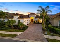 Beautifully landscaped home features a paver driveway and lush tropical landscaping with a barrel tile roof at 15520 Castle Park Ter, Lakewood Ranch, FL 34202