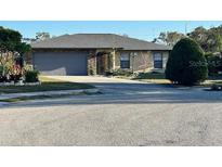 Charming single-story home with stone accents, a well-maintained lawn, and an attached two-car garage at 1842 Country Meadows Ct, Sarasota, FL 34235