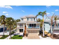 Stunning two-story home boasts multiple balconies, lush landscaping, and a charming coastal aesthetic at 204 66Th Street, Holmes Beach, FL 34217