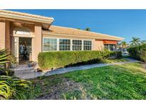 Inviting home entrance with lush landscaping, charming architectural details, and an open doorway to a naturally lit interior at 4414 Turnberry Ct, Bradenton, FL 34210