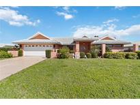 Charming single-story home with a manicured front lawn, two-car garage, and a stylish roof at 534 Warwick Ln, Venice, FL 34293