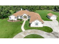 Expansive single-story home featuring a circular driveway and lush landscaping at 5750 Saddle Oak Trl, Sarasota, FL 34241