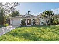 Charming single-story home featuring a well-manicured lawn and a welcoming entrance at 6232 Pecan Rd, Venice, FL 34293