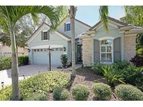 Charming single-Gathering home featuring lush landscaping, a brick driveway, and a welcoming front entrance at 12708 Stone Ridge Pl, Lakewood Ranch, FL 34202