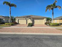 Charming paired villa featuring a brick drive, two-car garage, and manicured landscaping at 13602 Abercrombie Dr, Englewood, FL 34223