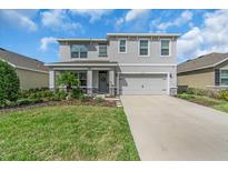 Charming two-story home with a well-manicured lawn and a welcoming front porch at 17119 Harvest Moon Way, Bradenton, FL 34211