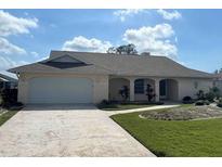 Charming single-story home featuring a two-car garage and well-maintained front yard at 26137 Dunedin Ct, Punta Gorda, FL 33983