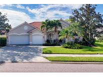 Charming single-story home with a red tile roof, manicured lawn and mature palm trees at 4705 Sweetmeadow Cir, Sarasota, FL 34238