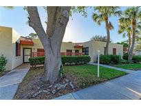 Charming condo exterior featuring mature landscaping, and a cozy front entrance with red latticework at 503 Spring Lakes Blvd # 503, Bradenton, FL 34210