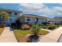 Condo exterior shows meticulous landscaping around building with neutral color scheme and white trim at 617 Estuary Dr # 617, Bradenton, FL 34209