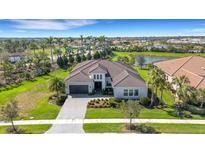 Stunning home with lush landscaping, tile roof, and serene surroundings by the lake at 8901 Artisan Way, Sarasota, FL 34240