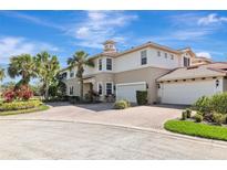 Elegant two-story home featuring a red tile roof, brick driveway, manicured landscaping and a two-car garage at 9415 Discovery Ter # 101A, Bradenton, FL 34212