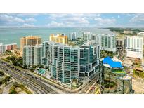 Stunning aerial view of a modern high-rise condominium building with waterfront views and cityscape at 1155 N Gulfstream Ave # 1709, Sarasota, FL 34236