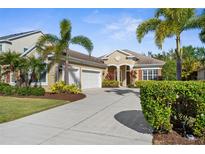 Beautiful single Gathering home with a two-car garage, manicured lawn, and lush tropical landscaping at 11603 Gramercy Park Ave, Bradenton, FL 34211