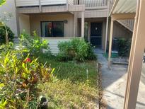 Inviting condo front entrance featuring well-maintained landscaping and covered parking at 1697 Brookhouse Cir # 116, Sarasota, FL 34231