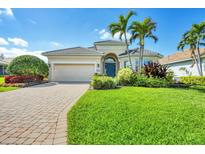 Beautiful single-story home featuring a paver driveway, lush landscaping and a well-manicured lawn at 1720 85Th Nw Ct, Bradenton, FL 34209