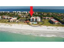 Beautiful aerial view of a beachfront condo building with a sparkling pool and access to the ocean at 1945 Gulf Of Mexico Dr # M2-516, Longboat Key, FL 34228