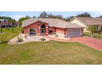 Charming single-story home with a well-manicured lawn, rock garden, and a two car garage at 215 Santarem Cir, Punta Gorda, FL 33983