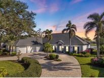 Stunning home showcasing lush landscaping, a circular driveway, and a three-car garage at 28 Dominica Dr, Englewood, FL 34223