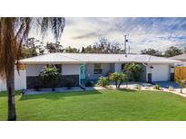 Charming single-story home with a well-maintained lawn, a metal roof, and a lovely light blue front door at 4210 Pandora Rd, Venice, FL 34293