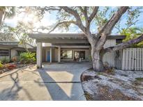 Inviting single-story home featuring covered parking and a mature tree providing shade and curb appeal at 4710 Gleason Ave, Sarasota, FL 34242