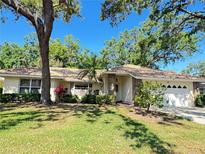 Charming single-story home featuring a well-maintained lawn, mature trees, and a tile roof at 5714 Garden Lakes Fern, Bradenton, FL 34203