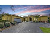 Charming single Gathering home with a two-car garage, arched entrance, and neatly landscaped yard at 6114 Misty Oaks St, Sarasota, FL 34243