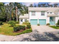 Charming two-story townhouse with light blue trim, a two-car garage, and a well-manicured lawn at 6639 Pineview Ter # 6639, Bradenton, FL 34203
