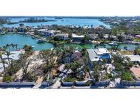 Stunning aerial view of a waterfront property surrounded by lush tropical landscaping and serene blue waters at 732 Siesta Dr, Sarasota, FL 34242