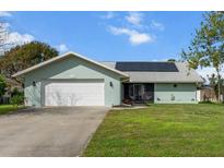 Charming single-story home with a two-car garage, solar panels, and a well-maintained front yard at 1239 Pinebrook Way, Venice, FL 34285