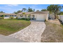 Charming single-story home with well-manicured lawn and brick driveway at 1565 Saturn Rd, Venice, FL 34293