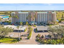 Beautiful exterior view of a multi-story condo building with palm trees, lush landscaping, and covered parking at 2320 Terra Ceia Bay Blvd # 406, Palmetto, FL 34221