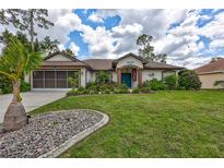 Charming single-story home featuring a well-manicured lawn and beautifully landscaped flowerbeds at 2625 Yuma Ave, North Port, FL 34286