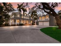 Beautiful two-story home with mature trees and a large driveway, including a separate two-story garage at 2828 Riverview Blvd, Bradenton, FL 34205
