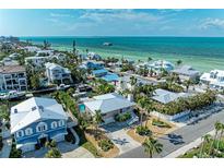 Beautiful coastal homes near the ocean, surrounded by lush landscaping and clear blue water at 526 Loquat Dr, Anna Maria, FL 34216