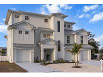 New construction three-story home with a two-car garage, manicured landscaping, and a contemporary architectural style at 597 Buttonwood Dr, Longboat Key, FL 34228